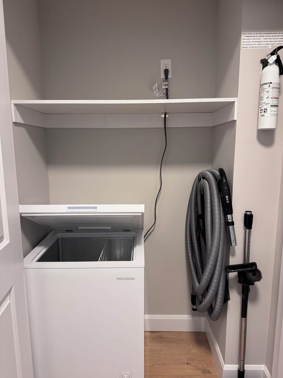 Hall closet with medium deep freezer, central vacuum, and additional storage