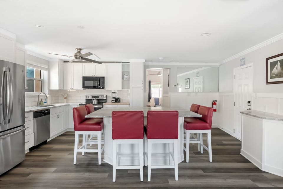 Bright, modern kitchen with island seating and sleek stainless-steel appliances.
