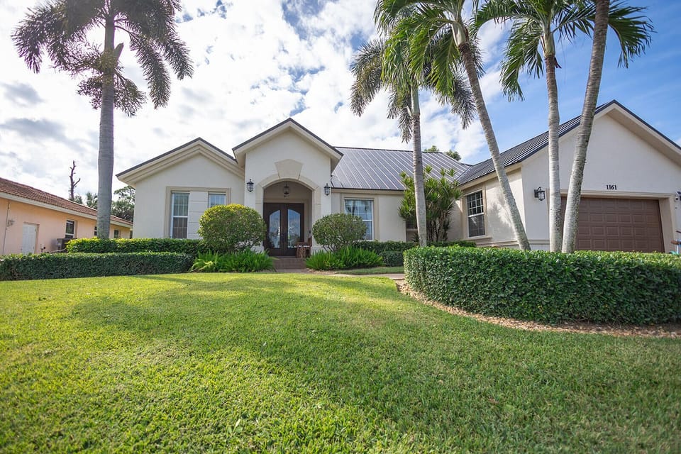 Tropical front yard with lush palms, your Marco Island escape begins here