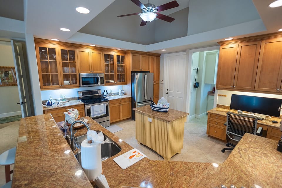Fully equipped kitchen with granite counters, island, and modern appliances.