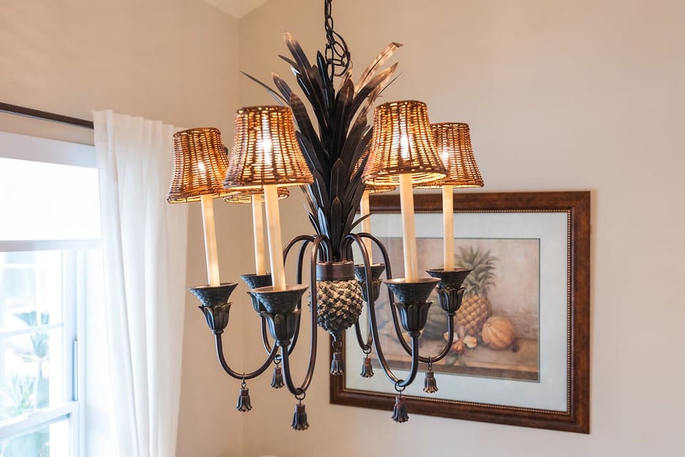 The tropical chandelier adds coastal charm and a warm glow to the dining area.