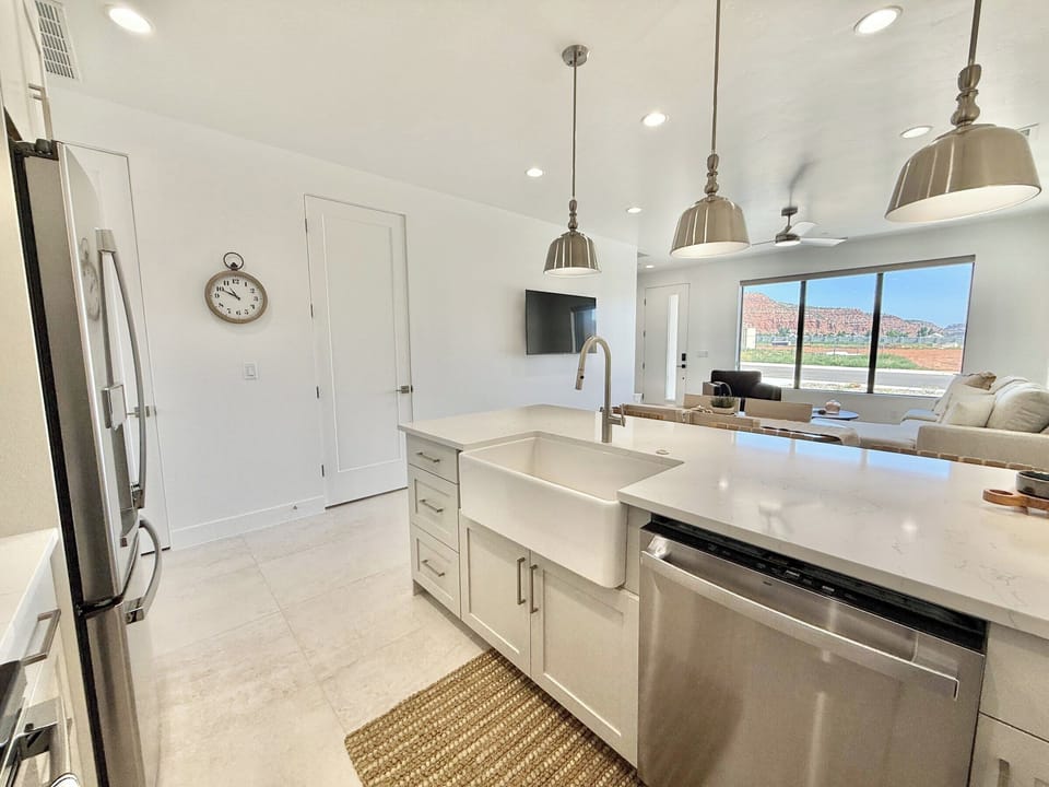Cook with a view! This modern kitchen and open-concept living space showcase stunning red rock mountains in Kanab, Utah.