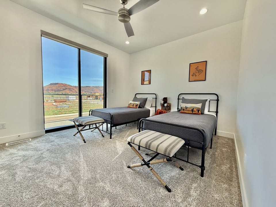 A fun and stylish kids' room with two beds and incredible desert views right from your window at Holiday H2, Kanab, UT.