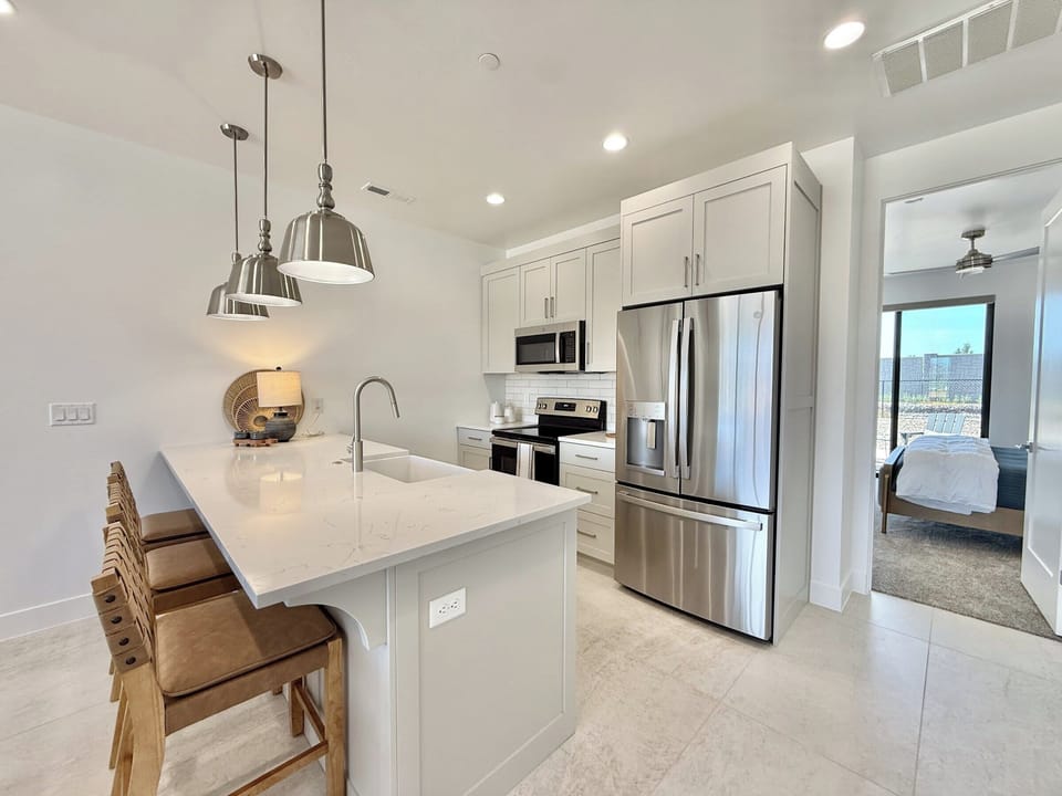 Cook in style! This modern kitchen at Holiday H2 at Catori features top-of-the-line appliances and a spacious island.
