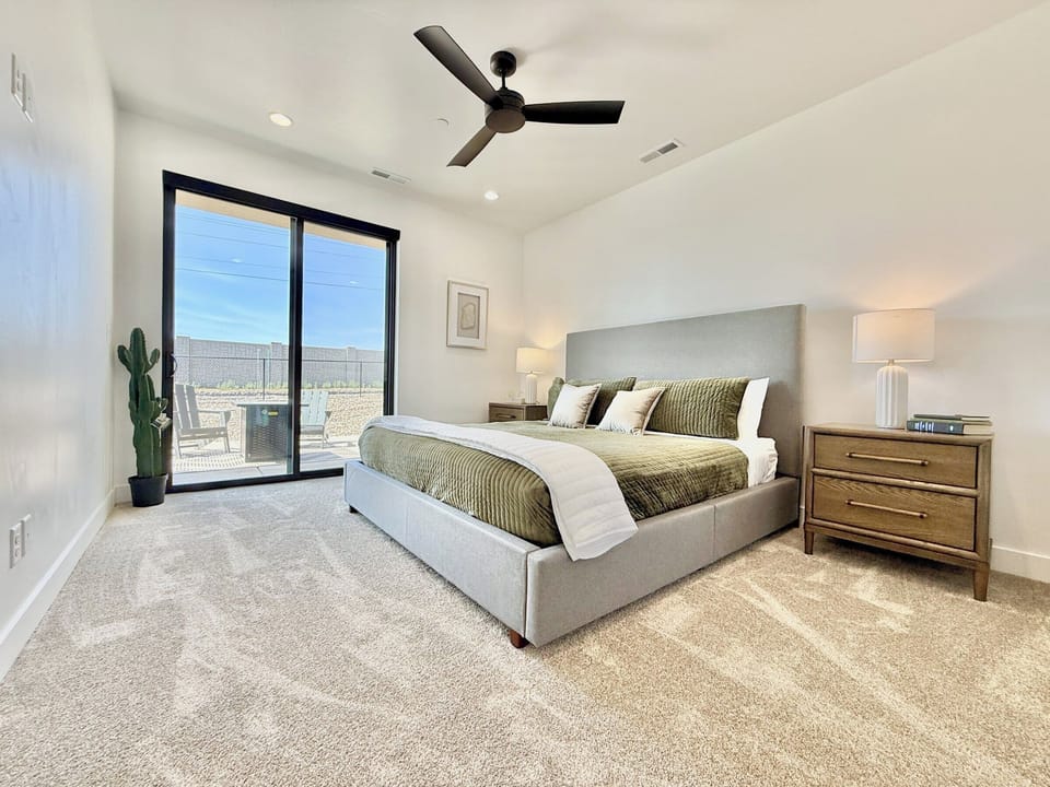 Serene primary bedroom with king bed and private patio access at Holiday H3 in Kanab, UT. Luxury awaits!