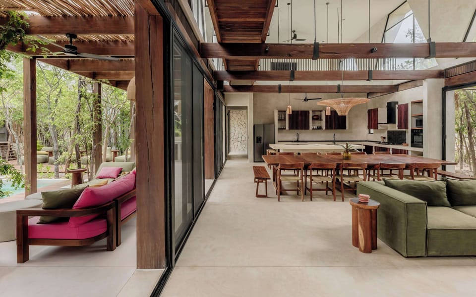 Open-plan dining and kitchen flowing toward the jungle garden.