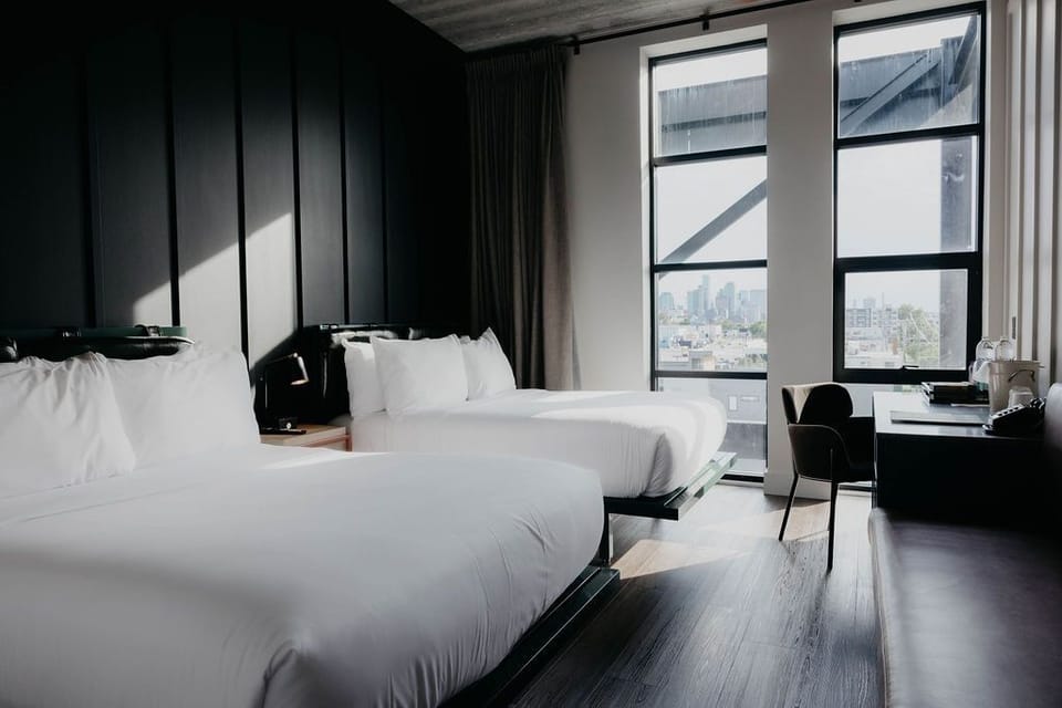 Wake up to skyline views beside bright windows and desks.