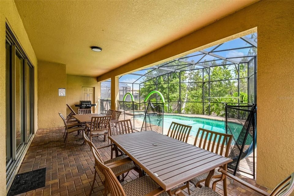 Outdoor eating area within screened lanai.