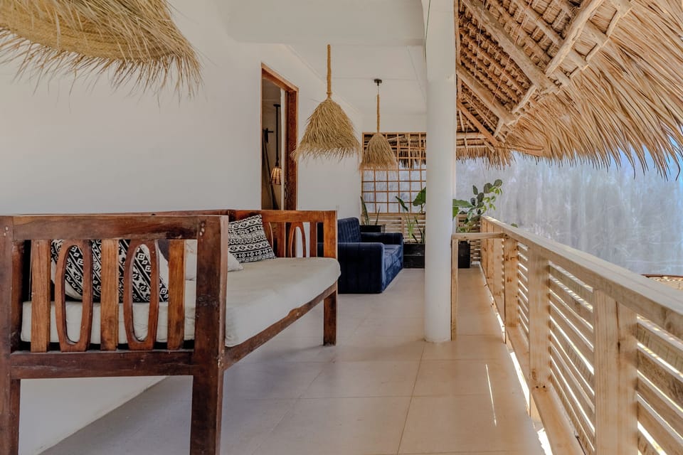 Relax on this breezy tropical veranda with cozy lounge seating