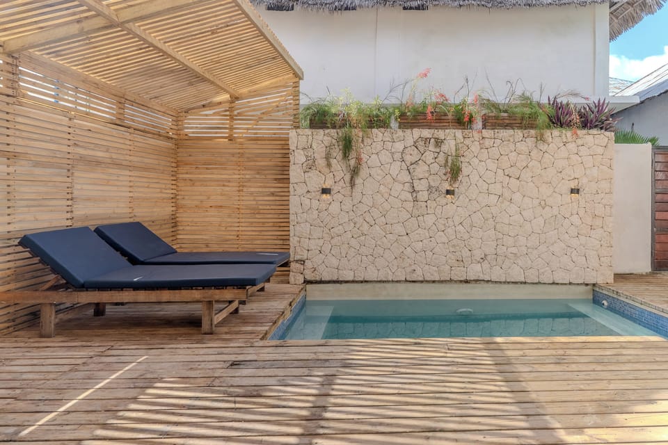 Private plunge pool with shaded loungers and tropical-style deck