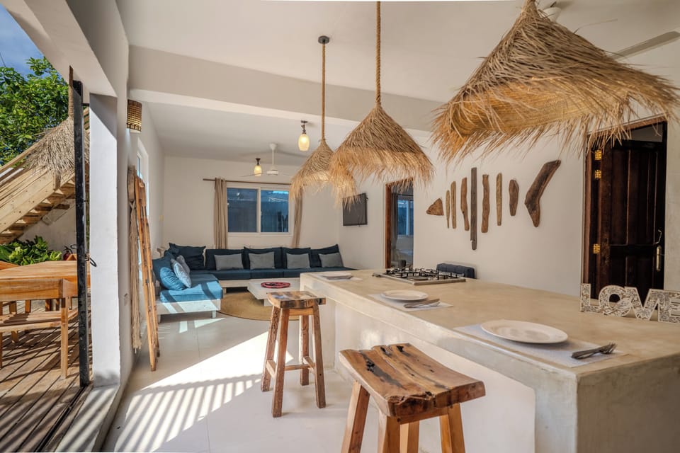Bright tropical living space with breakfast bar and breezy indoor-outdoor flow