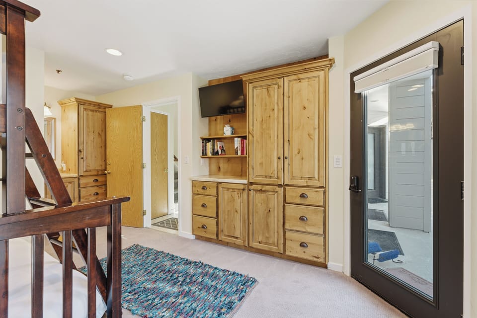 This bunk bedroom space offers ample built-in storage, natural light, and convenient access to the outdoor patio.