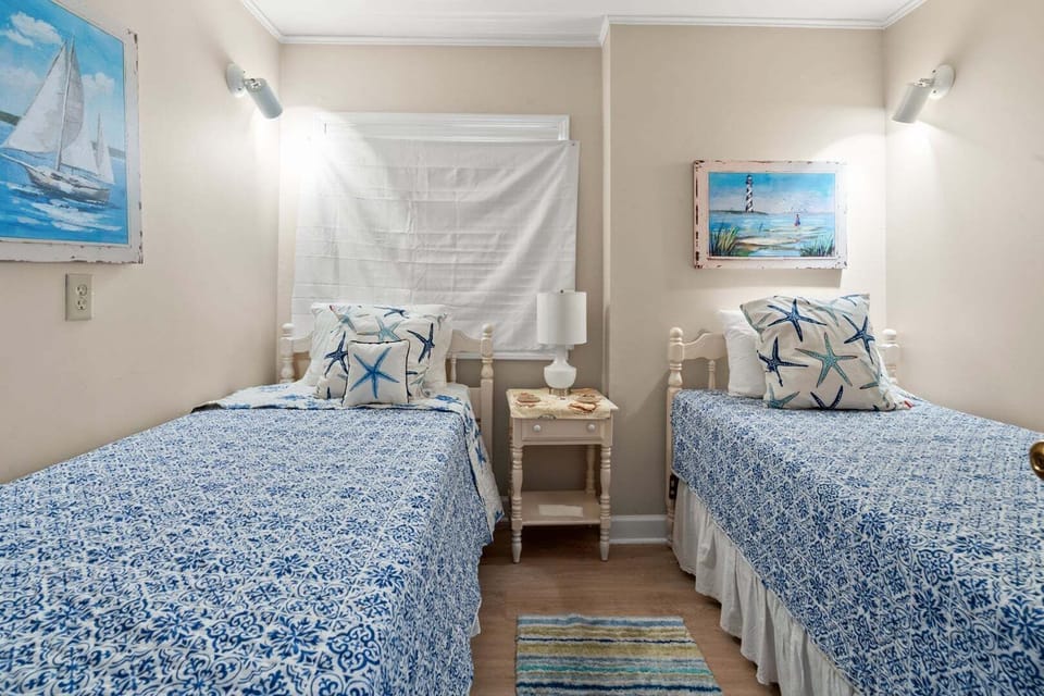 Two beds with nautical bedding and boat artwork at Sea Pointe 702, a Cherry Grove vacation rental