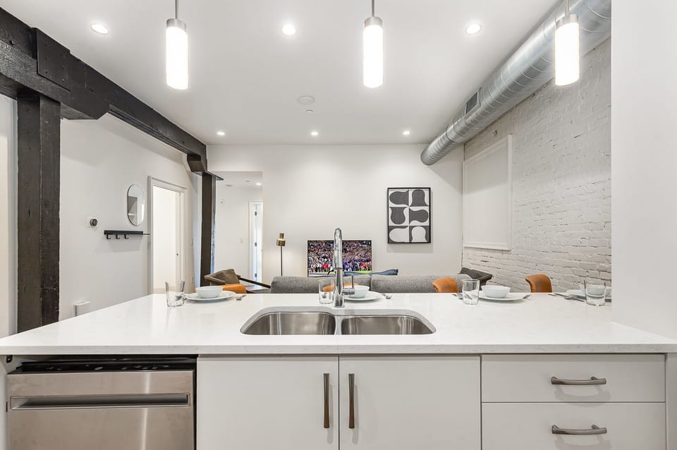 Unit 1: Fully equipped kitchen featuring stainless steel appliances, open counter space, and bar seating for 5 guests. (4th Floor)