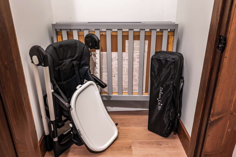 folded baby crib and high chair stored in a corner