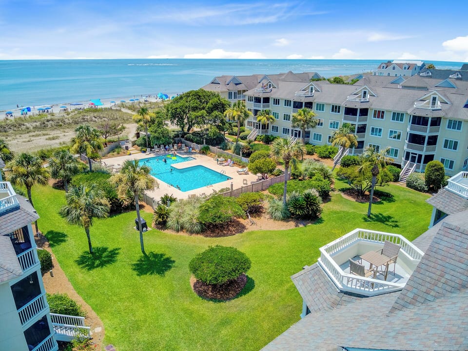 Aerial of pool area and buildings nestled in greenery.