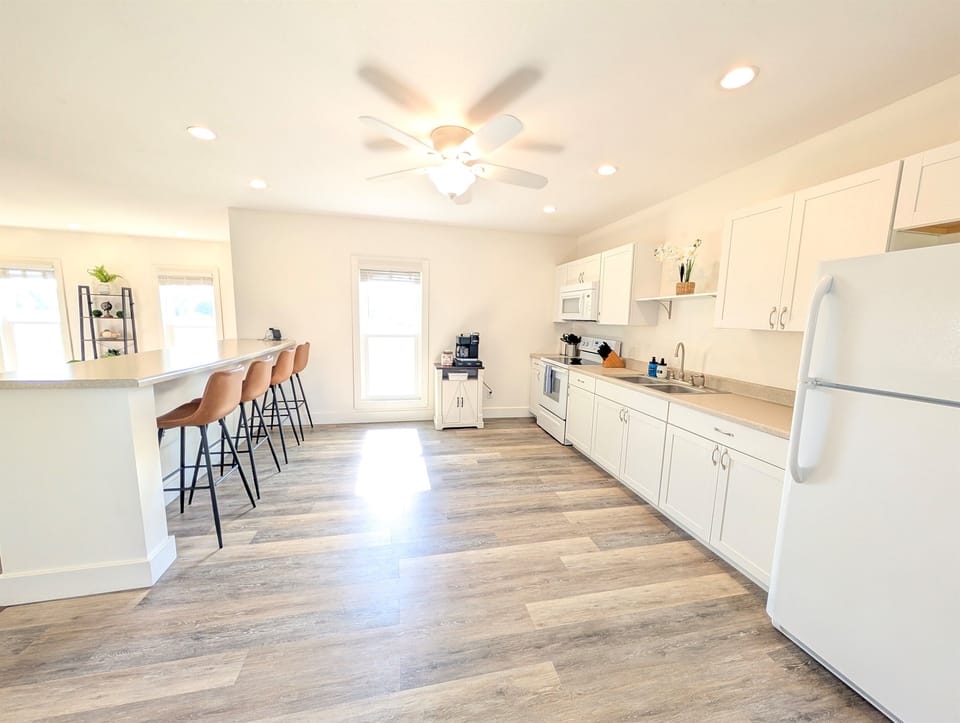 Fully stocked kitchen with coffee bar and seating for 4 at the kitchen counter.