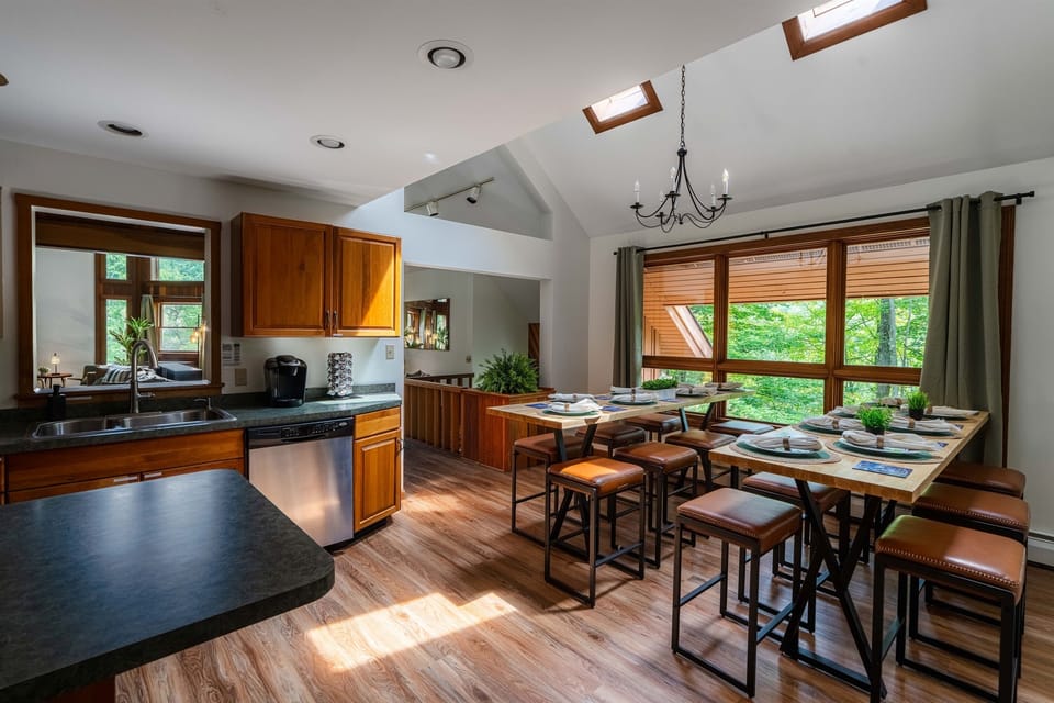 Cook, connect, and dine in style—our fully stocked kitchen flows into a custom-built dining area with seating for 17 and treetop views.