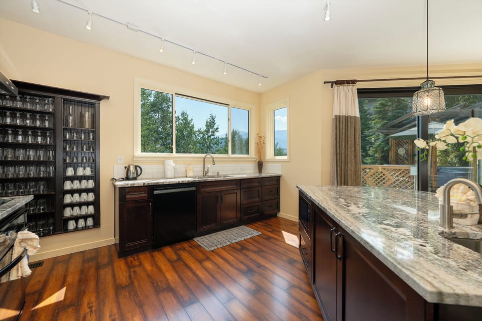 Your gourmet kitchen features granite countertops, rich wood cabinetry, and gleaming hardwood floors, perfect for preparing memorable meals during your stay.