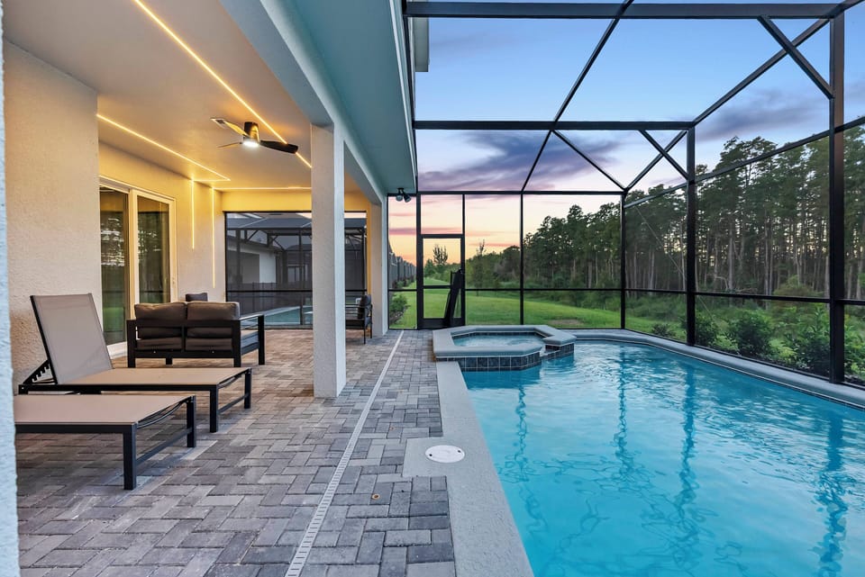 Unwind by the shimmering pool on our screened-in patio, where privacy meets stunning views of lush greenery. With inviting lounge chairs and sleek outdoor furniture, it's the perfect spot to relax after your adventures.