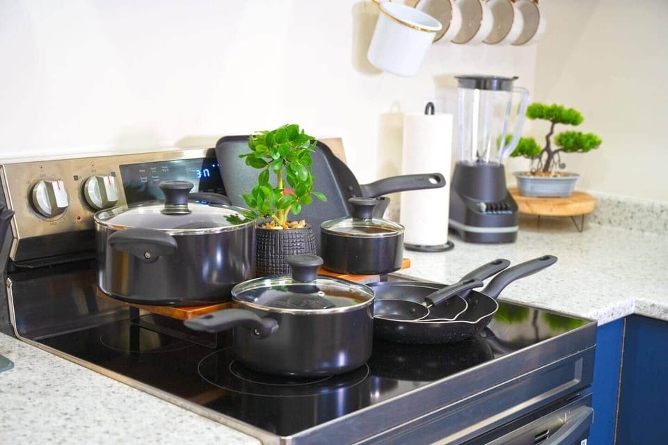 Fully equipped kitchen with everything you need to cook and dine in, including a stove, oven, fridge, microwave, dishwasher, water dispenser, pots, pans, and utensils. Perfect for enjoying home-cooked meals during your stay!