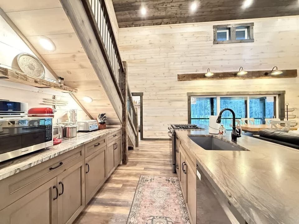 Very open kitchen with appliances, pots and pans, basic cooking essentials, dishes, and utensils.