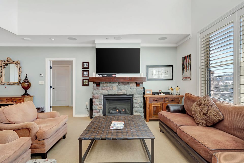 - Spacious living room with mountain-view windows   - Cozy stone fireplace and smart TV for relaxing nights   - Ideal for ski trips and family gatherings in style