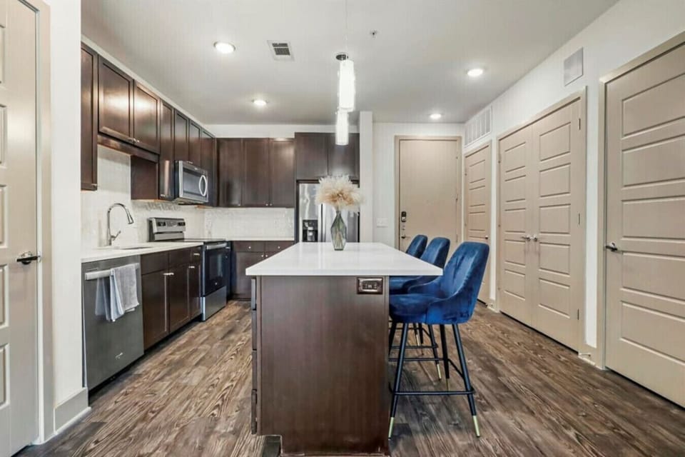 Fully equipped kitchen featuring quartz countertops and seating for casual meals.