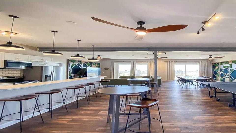 Family area which features living room, dining area, kitchen island with chairs, full kitchen, ping pong table