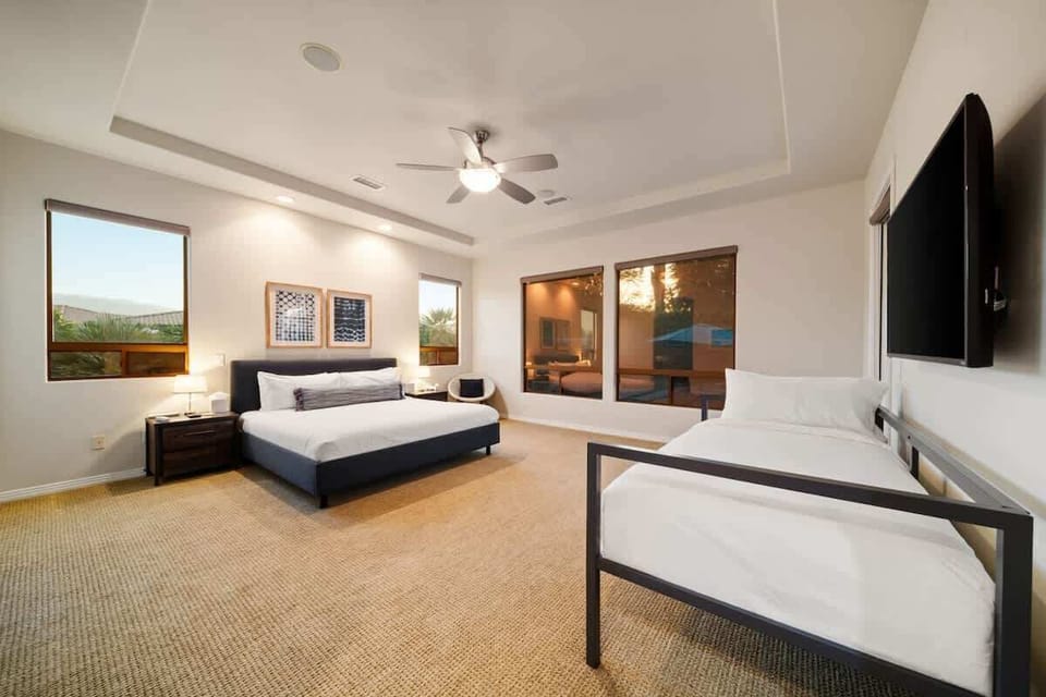 Spacious primary suite features a king bed, twin daybed, and a smart TV—perfect for couples or families seeking comfort and convenience.