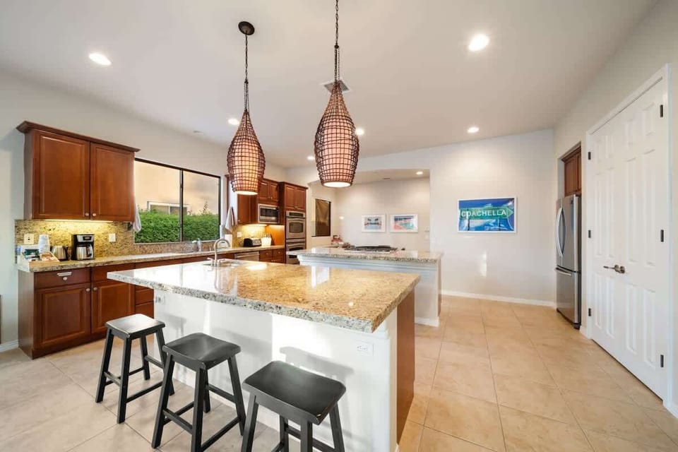 A chef’s paradise: granite countertops, double ovens, and stylish pendant lighting make this kitchen the heart of the home.