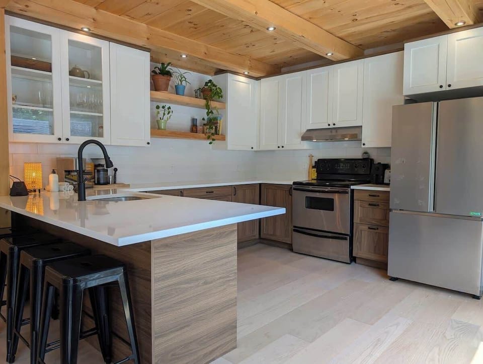 Cuisinez avec style grâce à des appareils modernes et des accents de bois naturel – une touche d’élégance au cœur de la nature!