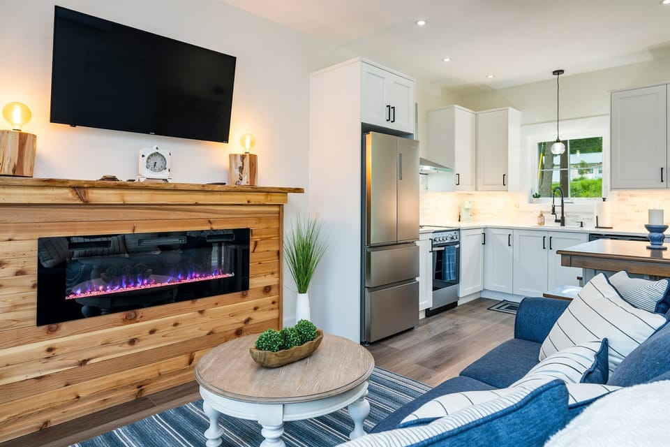 Cozy up in this inviting living area featuring a modern electric fireplace, smart TV, and seamless flow into the kitchen.