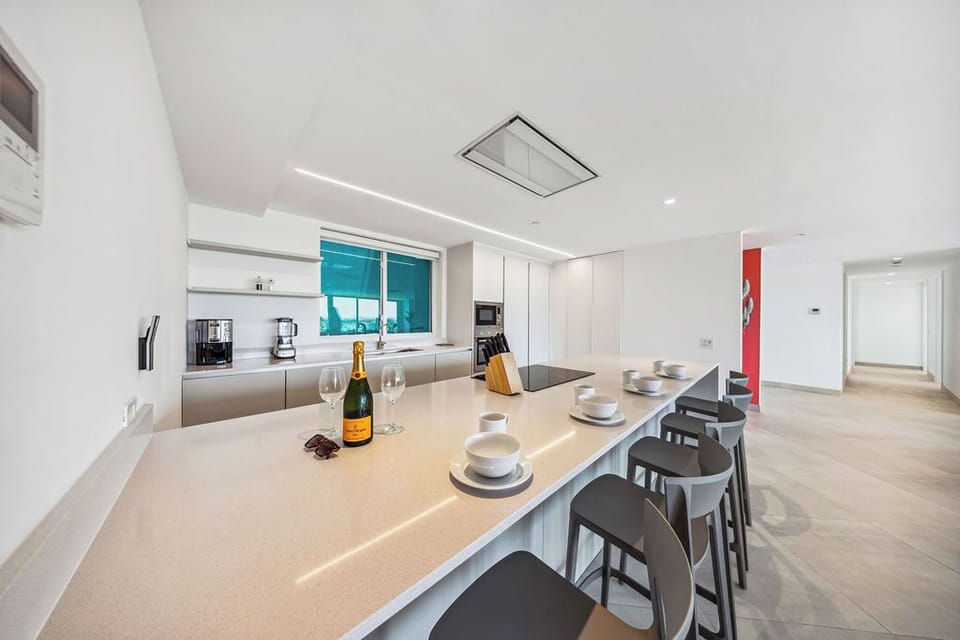 Gather around the sleek island with champagne in hand, ready to create unforgettable meals in your modern, light-filled kitchen with top-of-the-line appliances.