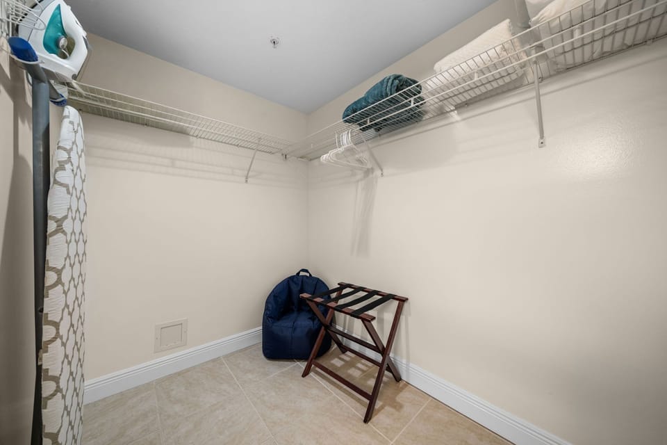 spacious walk-in closet with wire shelving and seating area