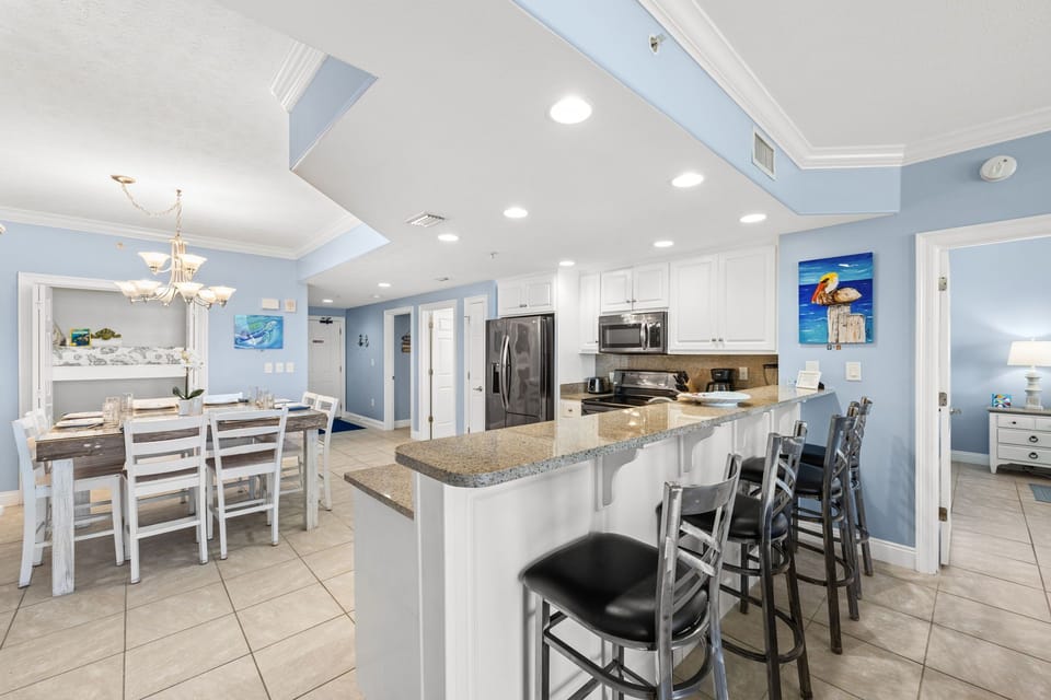 Open kitchen and dining area with modern appliances and seating for casual meals.