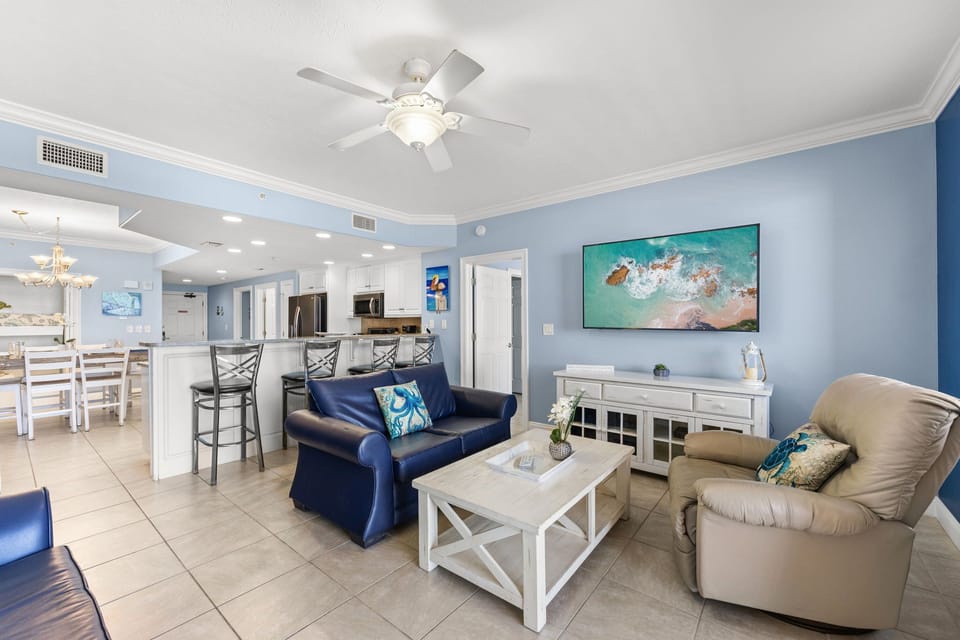 Open-concept living area with coastal-inspired decor and a fully equipped kitchen.