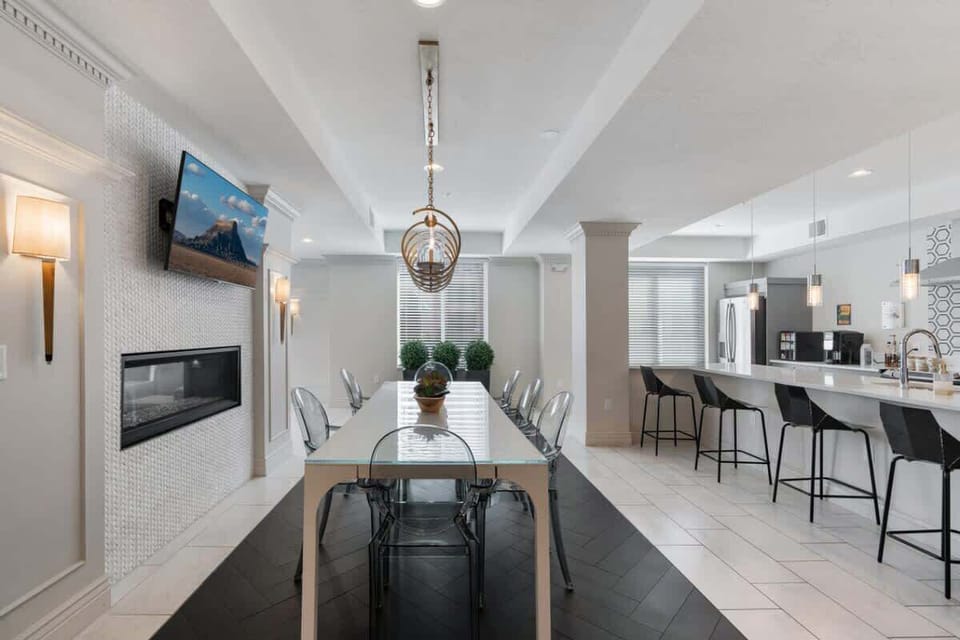 Dine in elegance under a beautiful chandelier, with natural light streaming through the large window.