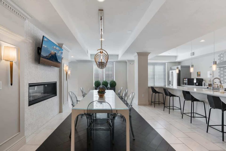 Dine in elegance under a beautiful chandelier, with natural light streaming through the large window.