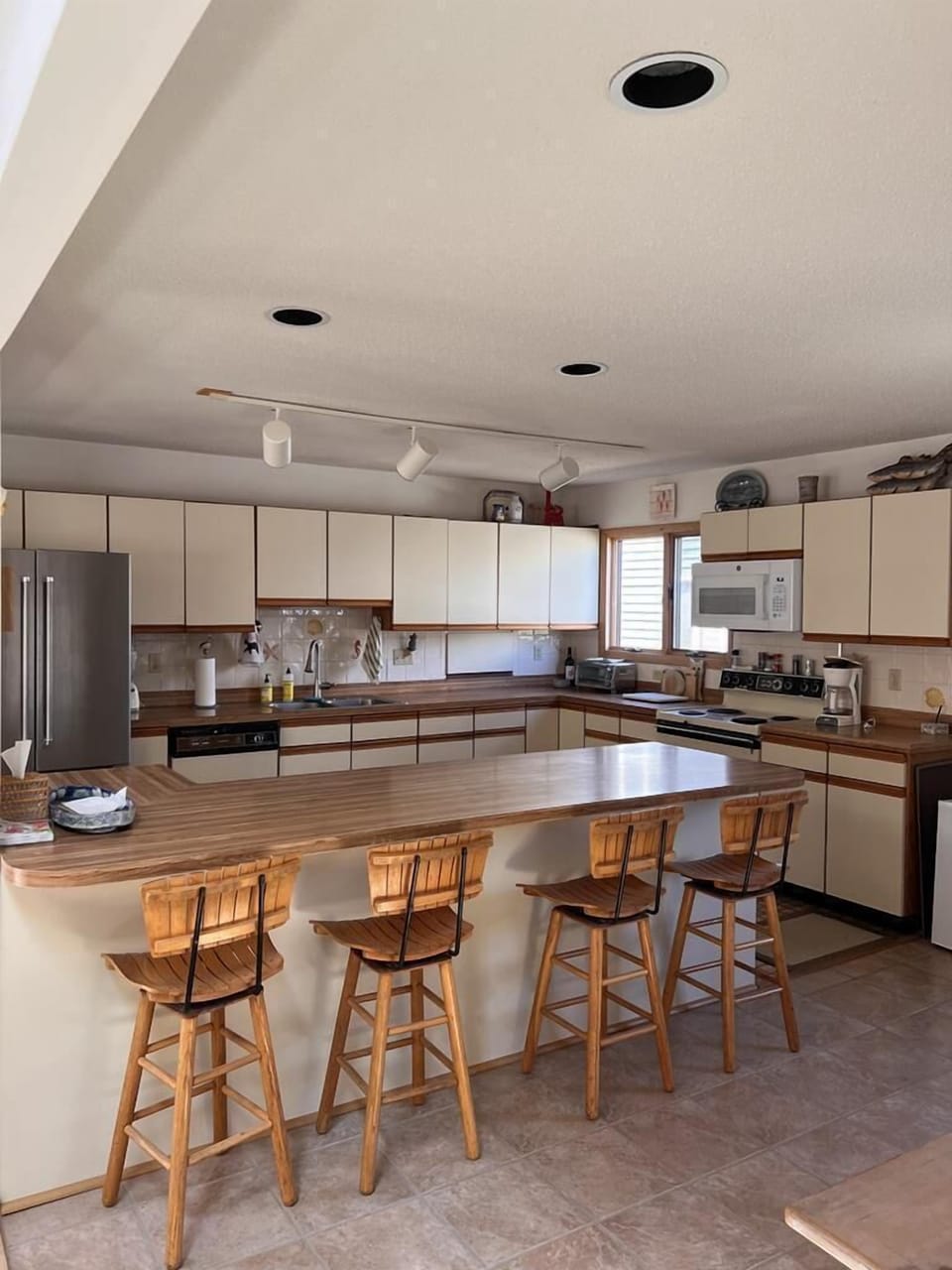 A fully equipped kitchen with modern appliances and a breakfast bar, ideal for preparing meals and entertaining.