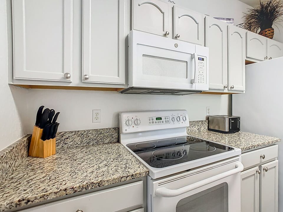 Spacious kitchen with appliances and granite countertops.