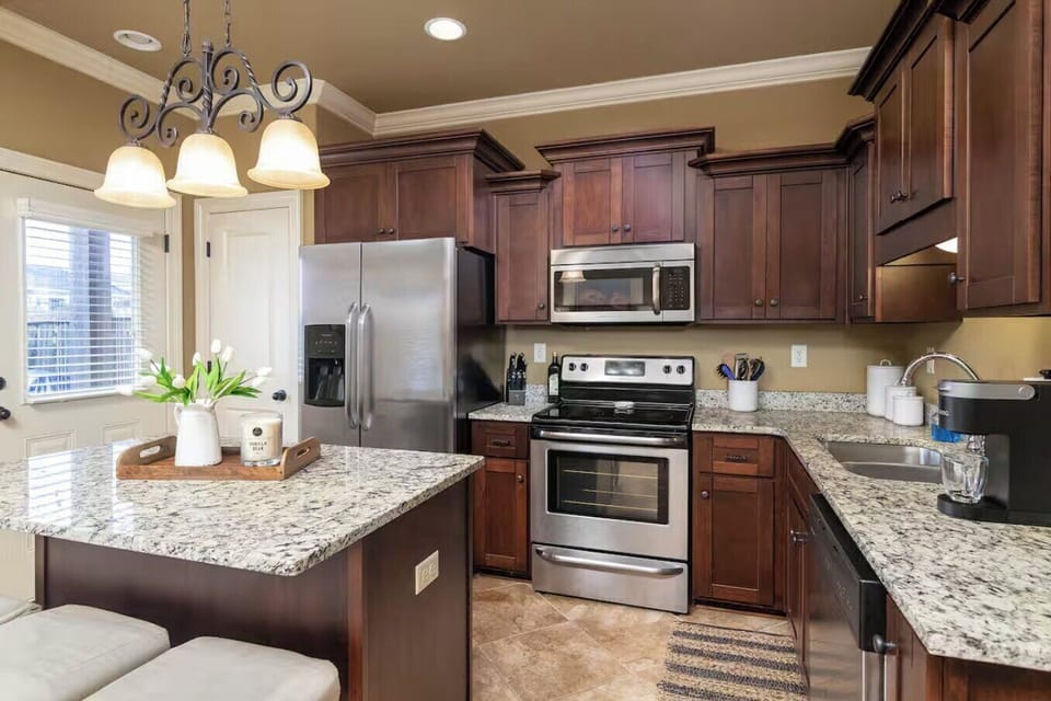 Spacious kitchen with stainless steel, cooking accessories, granite countertops