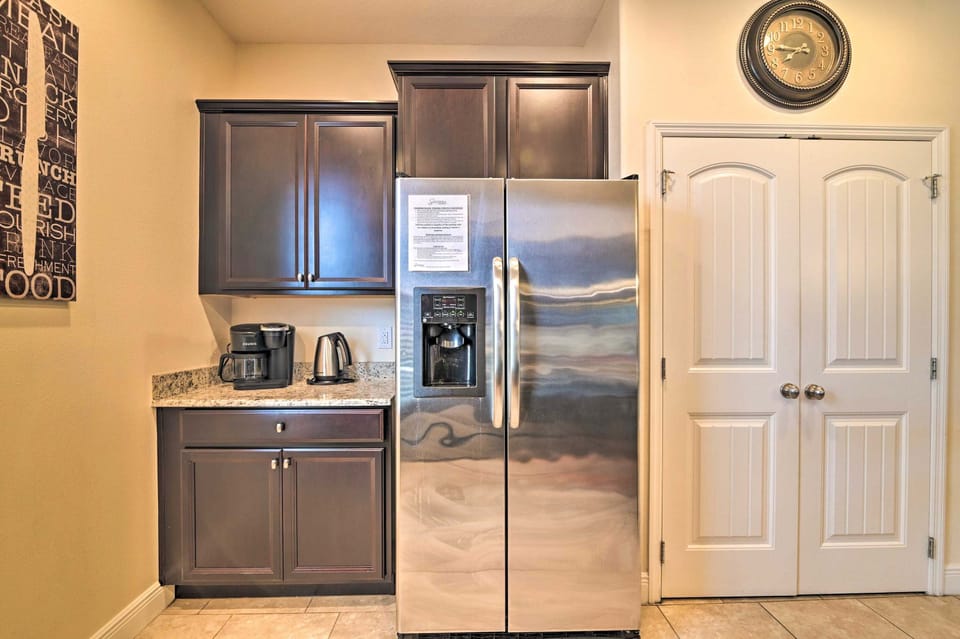 modern kitchen area featuring a stainless steel refrigerator and dark wood cabinets