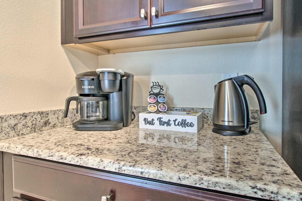 Granite countertop with coffee maker and electric kettle for convenient morning beverages.