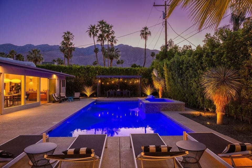 Enjoy magical desert evenings with illuminated landscaping, a glowing pool, and mountain views.