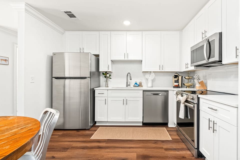 Modern kitchen with stainless appliances, in-unit laundry, and dining for four.