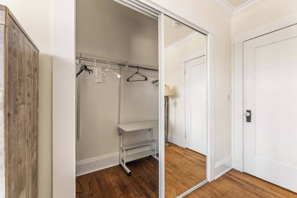 A serene bedroom with a queen-size bed, complemented by a spacious dresser and built-in closet for clothing storage. Soft, neutral tones and gentle lighting create a clean, calming space perfect for rest and organization