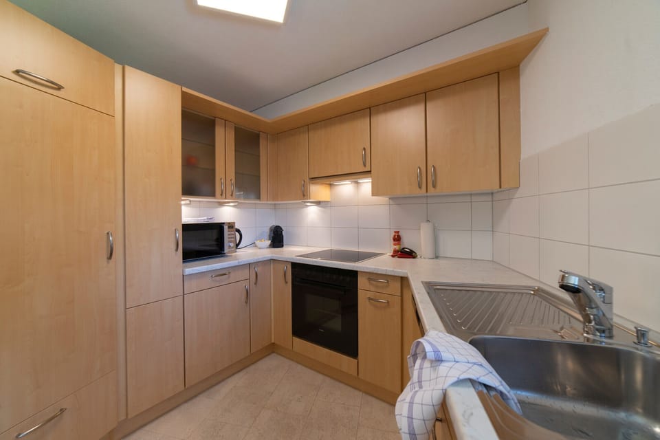 Compact kitchen with wooden fronts, an oven and a sink