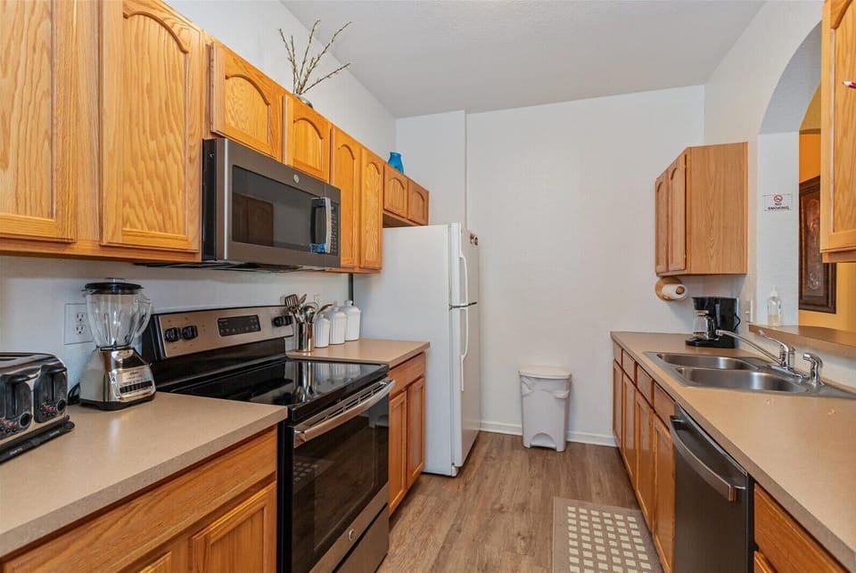 functional kitchen with wooden cabinets and modern appliances for convenient cooking