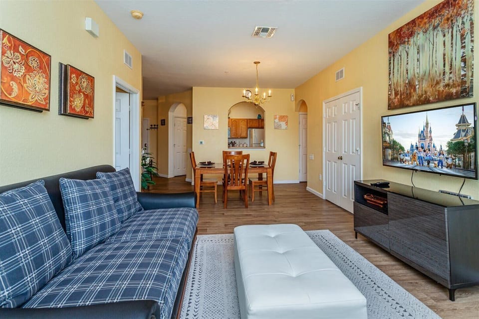 Open living and dining area with modern furnishings and a large television.